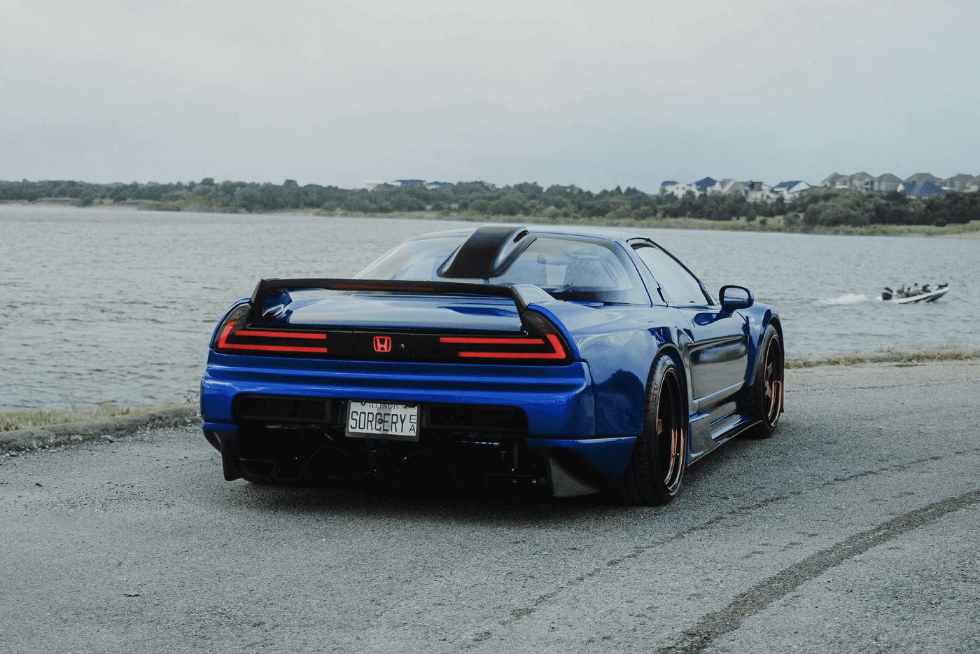 Rear three-quarter view of the NSX showing the carbon fiber wing and LED taillights